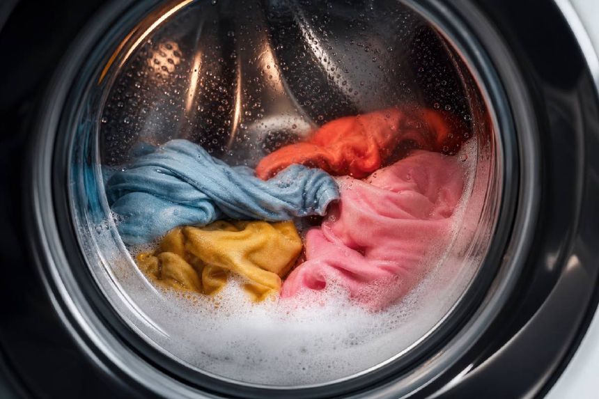 Haine colorate vazute prin hubloul masinii de spalat