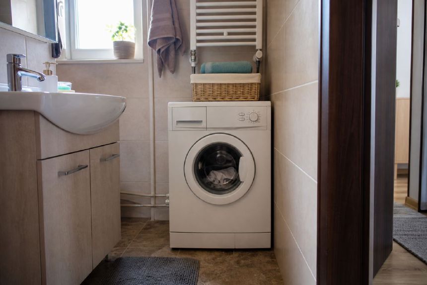 Masina compacta instalata intr-o baie moderna